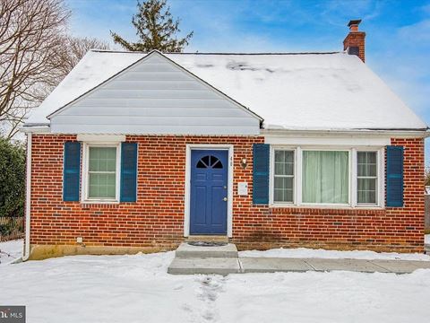 a small brick house with a blue door in the snow