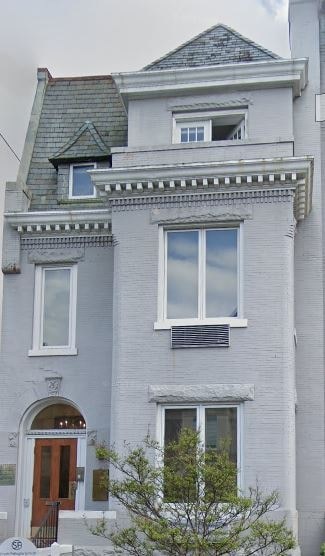 A grey two story house with a brown door.
