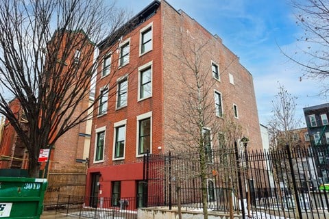 a red brick building with a fence in front of it
