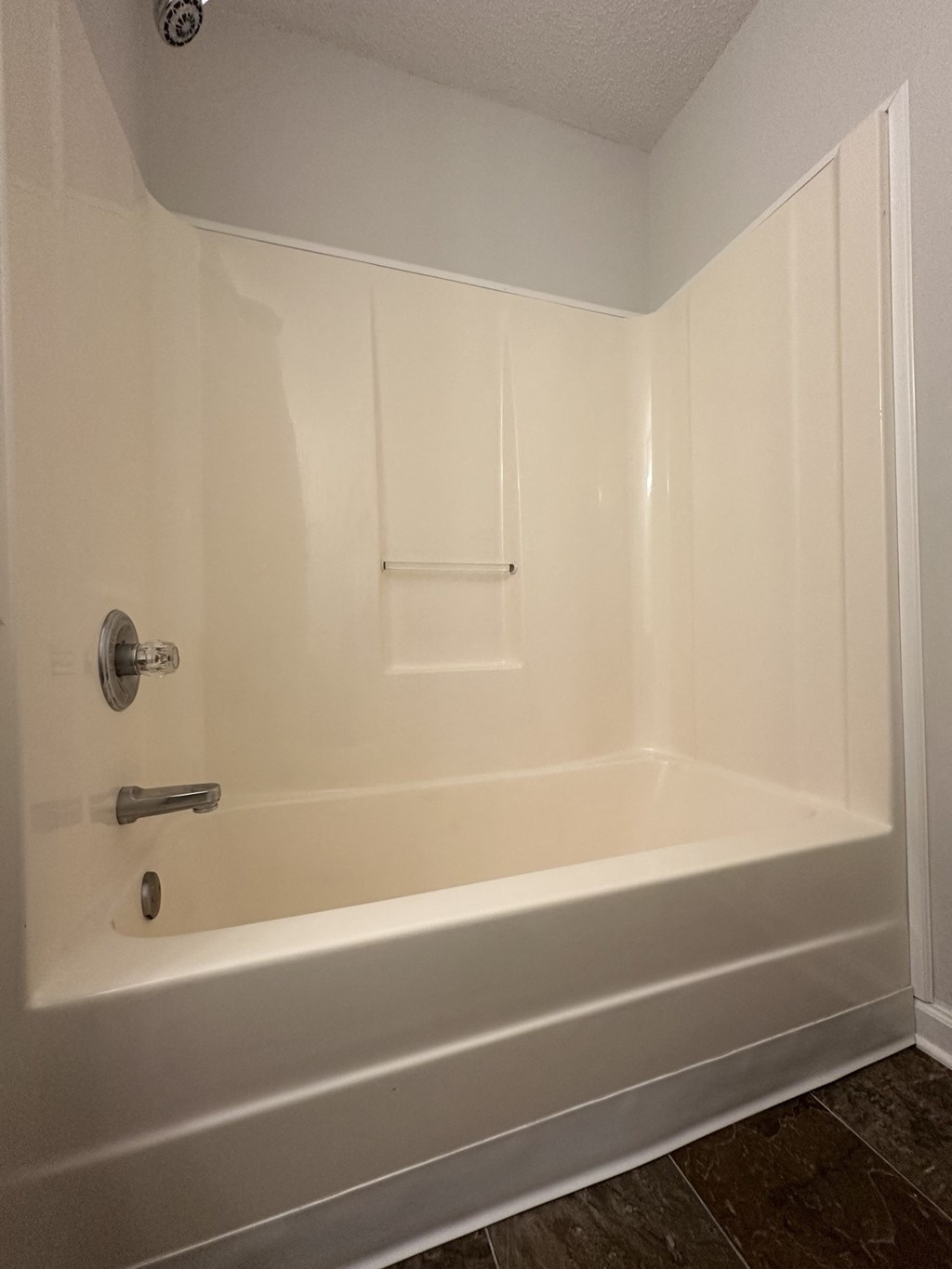 A white bathroom with a tub and a door.