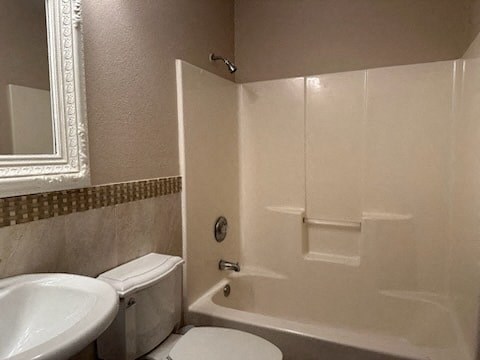 a bathroom with a white toilet and a tub and a sink