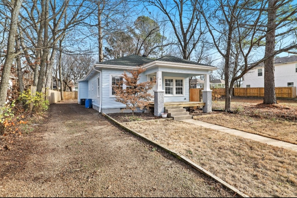 a small white house with a yard and trees