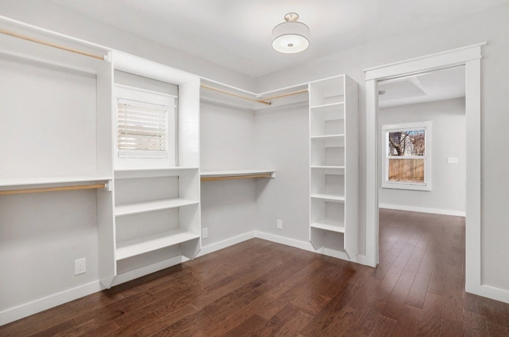 an empty room with white shelves and a wood floor