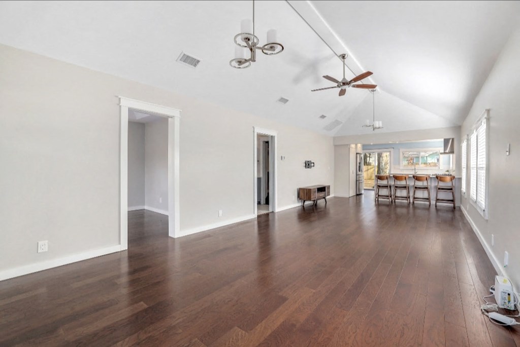 a large living room with a hard wood floor and a ceiling fan