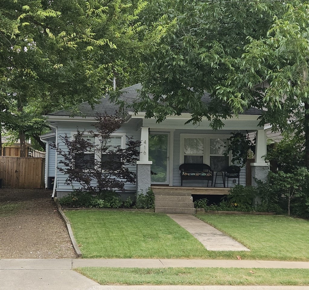 a small house with a porch and a lawn