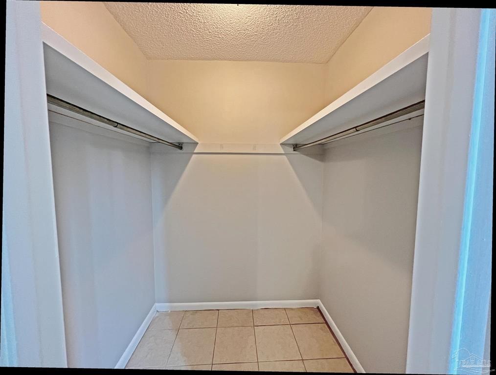 a walk in closet with white walls and sliding closet doors