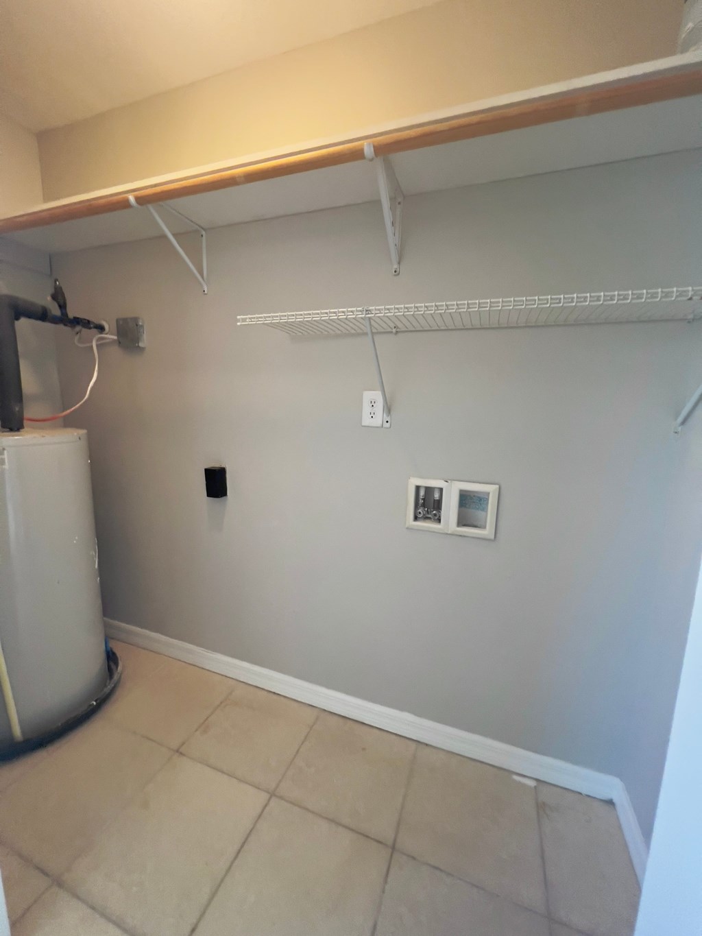 a room with a dryer and a shelf on the wall