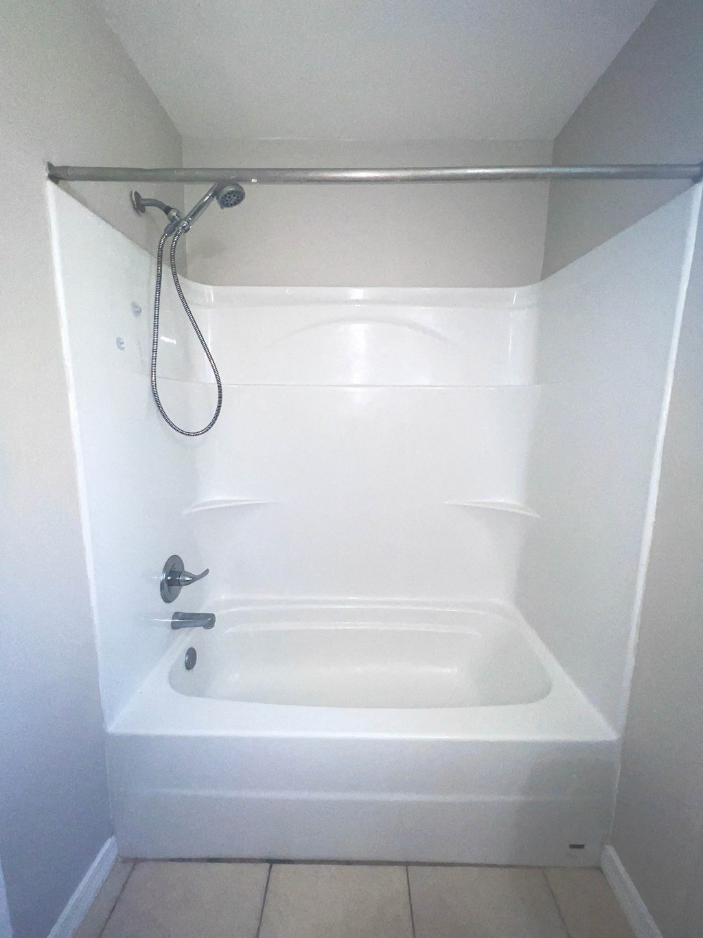 a small shower in a bathroom with a shower curtain