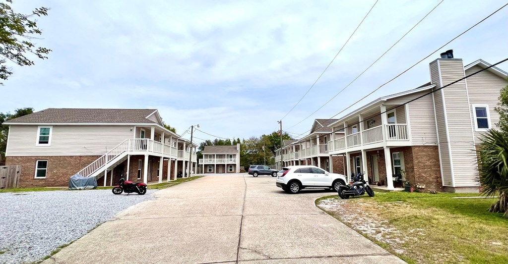 a row of houses with cars parked on the street