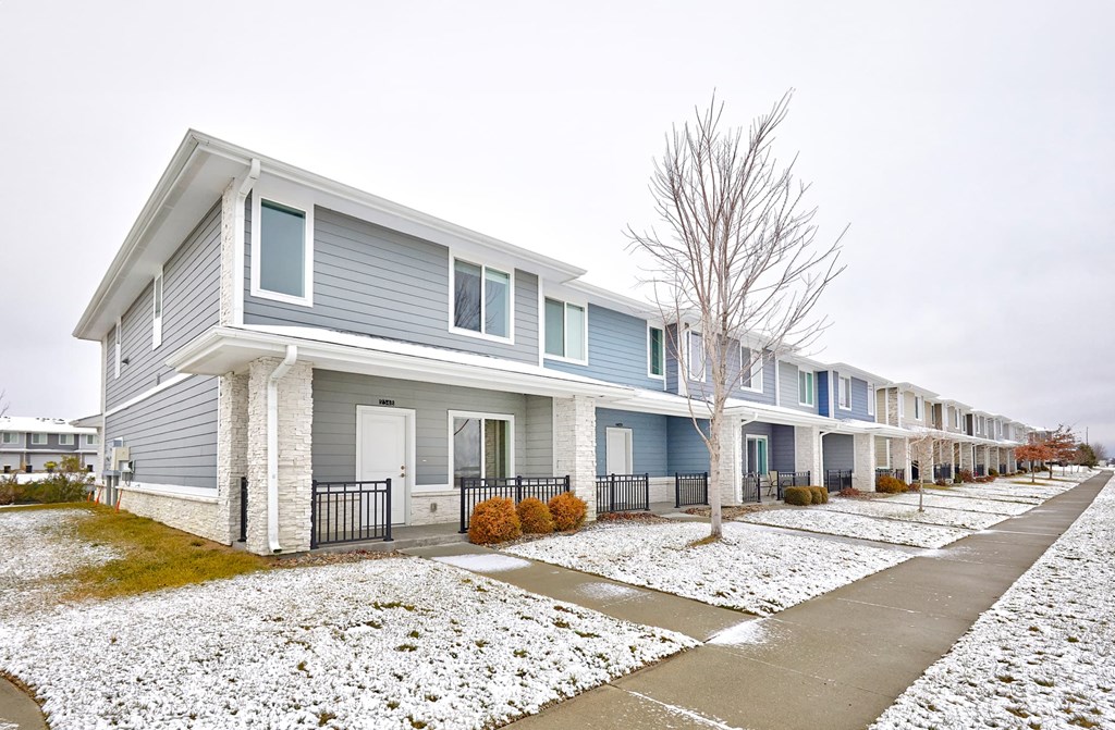 A row of houses with snow on the ground.