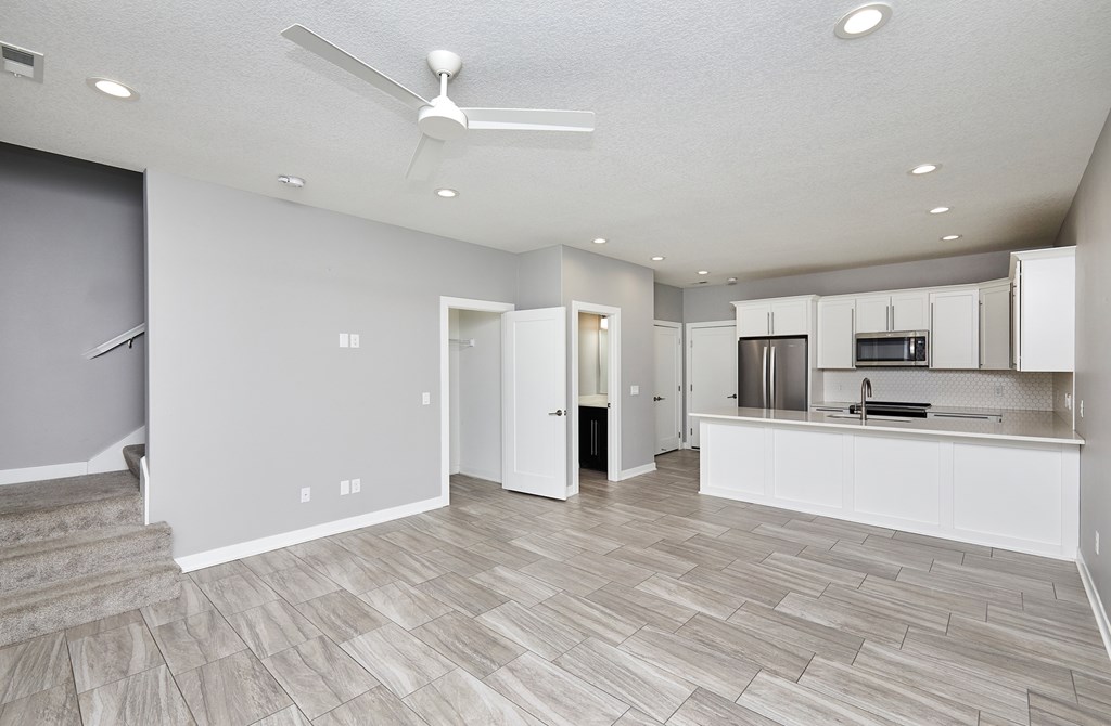 A spacious kitchen with a fan on the ceiling.
