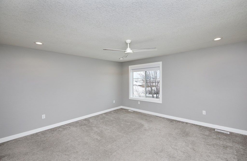 A room with a ceiling fan and a picture on the wall.