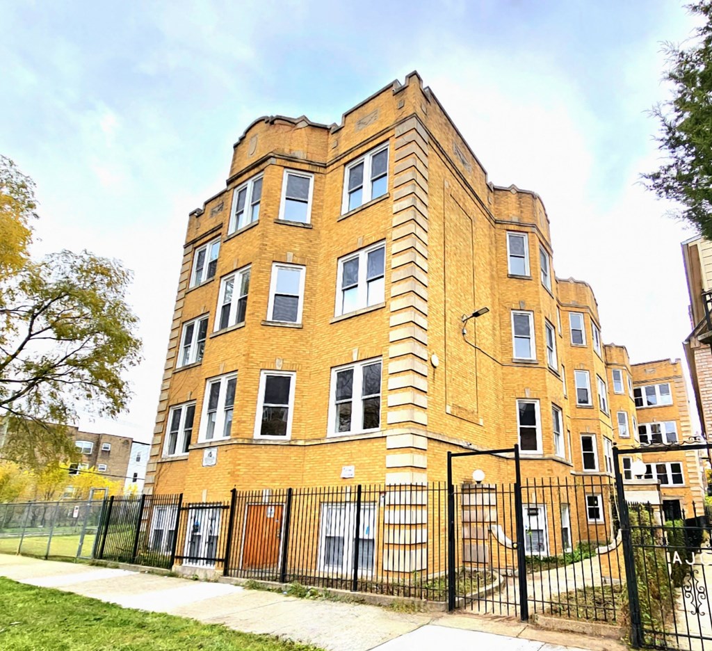 a tall brick building with a fence in front of it
