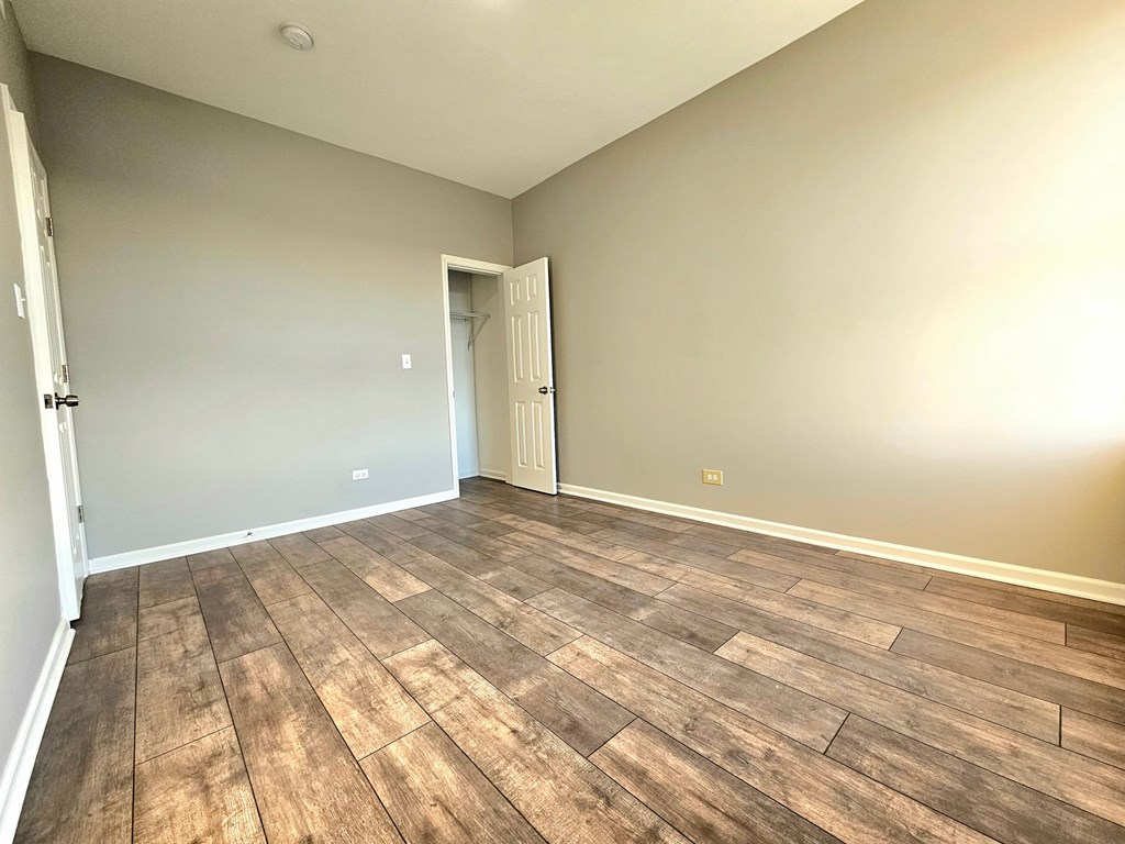 an empty living room with wood flooring and a door