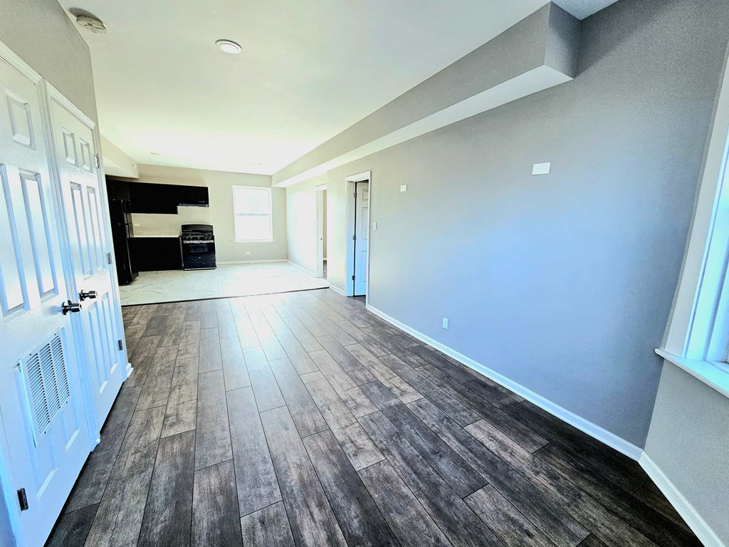 a empty living room with wood floors and blue walls