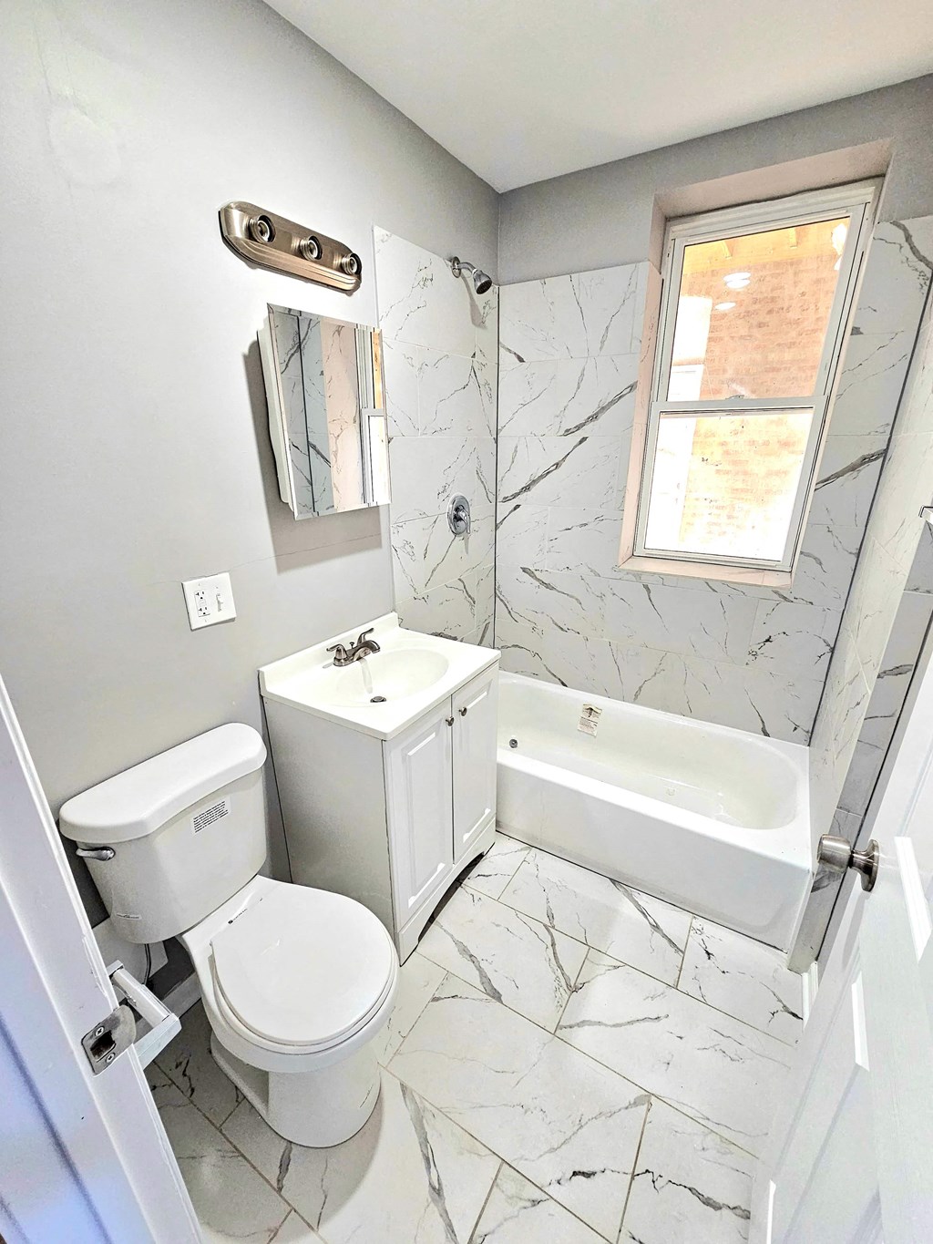 a bathroom with a toilet and a tub and a sink