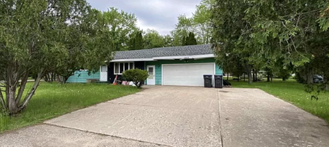 a blue house with a driveway and a garage door