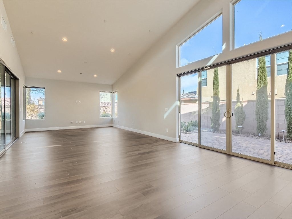 an empty living room with large windows and wood floors