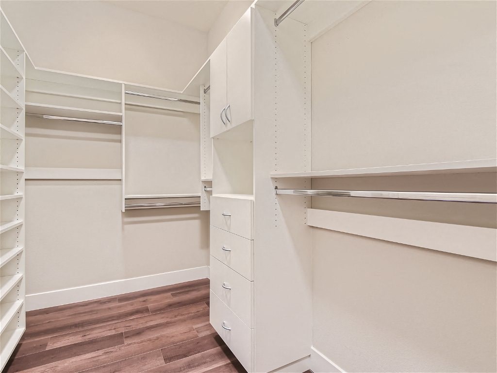 a large walk in closet with shelves and drawers