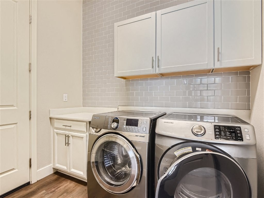 a washer and dryer in a laundry room with white cabinets