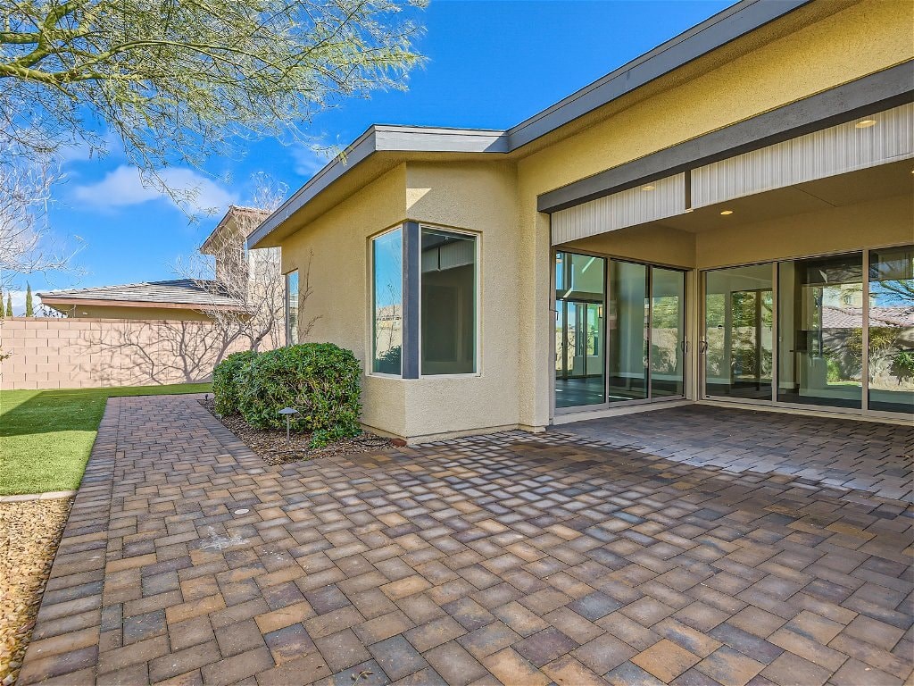 a brick patio in front of a house with glass doors
