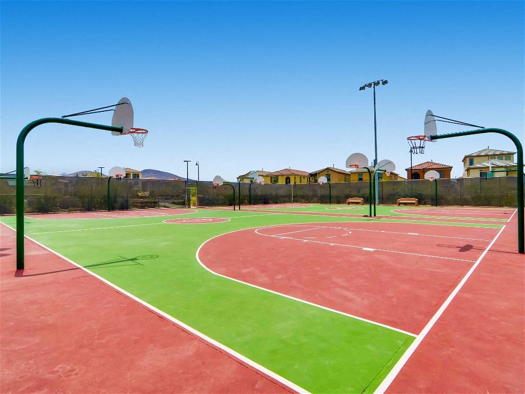 a green and red basketball court in a park