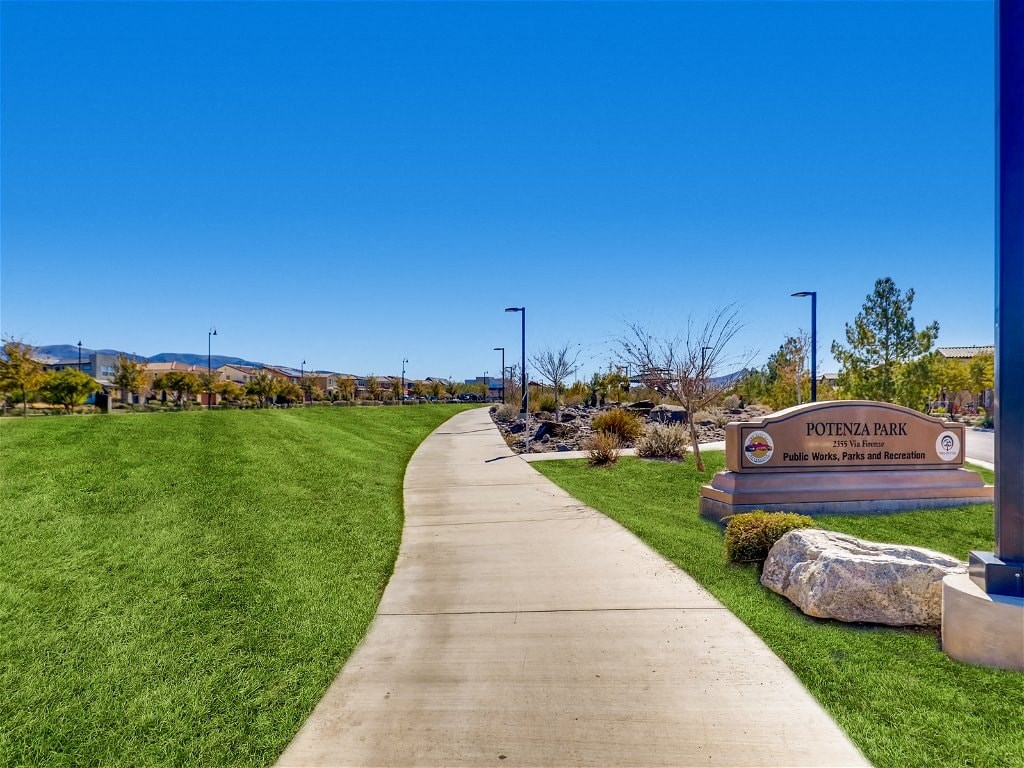 a sidewalk running through a park with a sign park