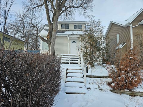 a house with snow covered steps in front of it