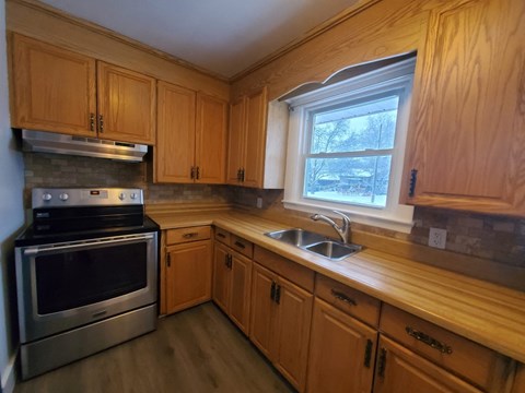 a kitchen with wooden cabinets and stainless steel appliances