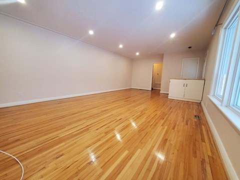 a living room with a hard wood floor and a window
