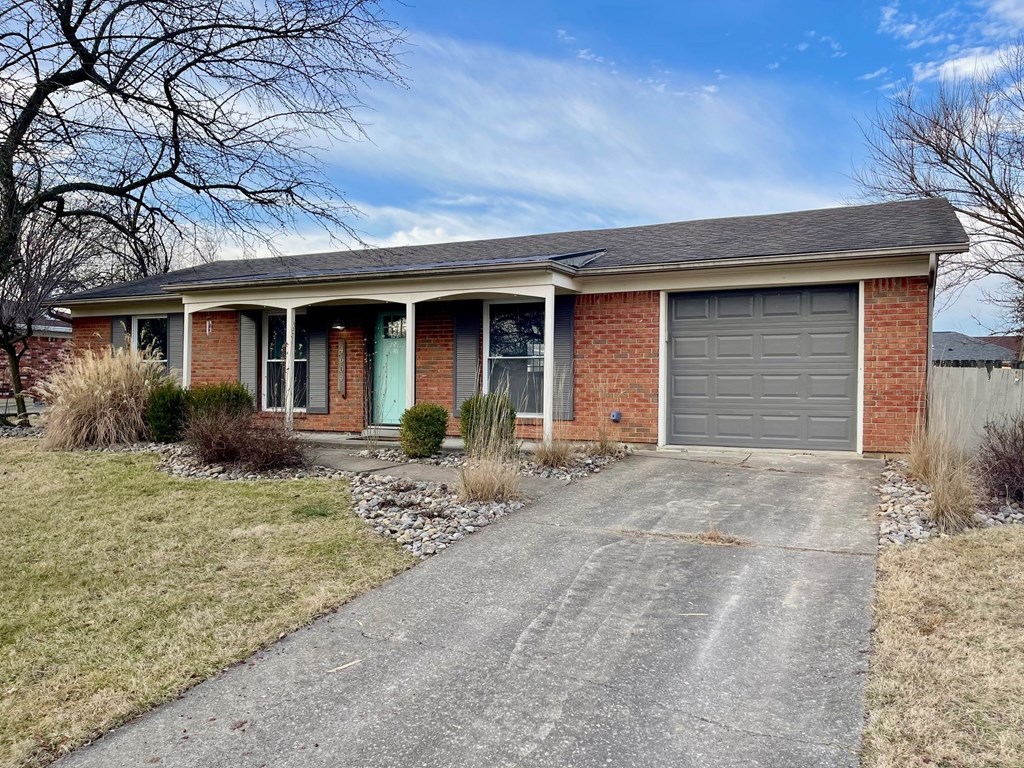 A house with a grey garage door and a green door.
