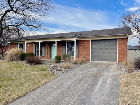 A house with a grey garage door and a green door.