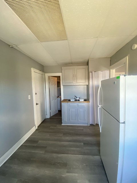 A kitchen with a refrigerator on the right side.