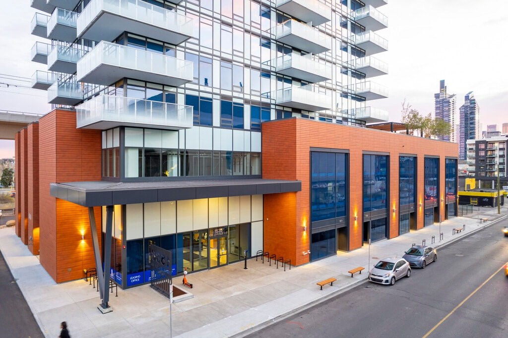 A modern building with orange and blue accents and a glass facade.