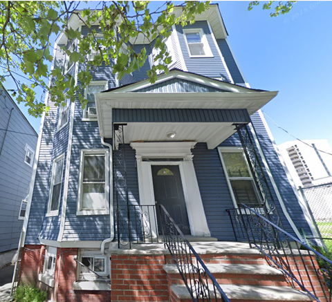 the front of a blue house with stairs and a roof