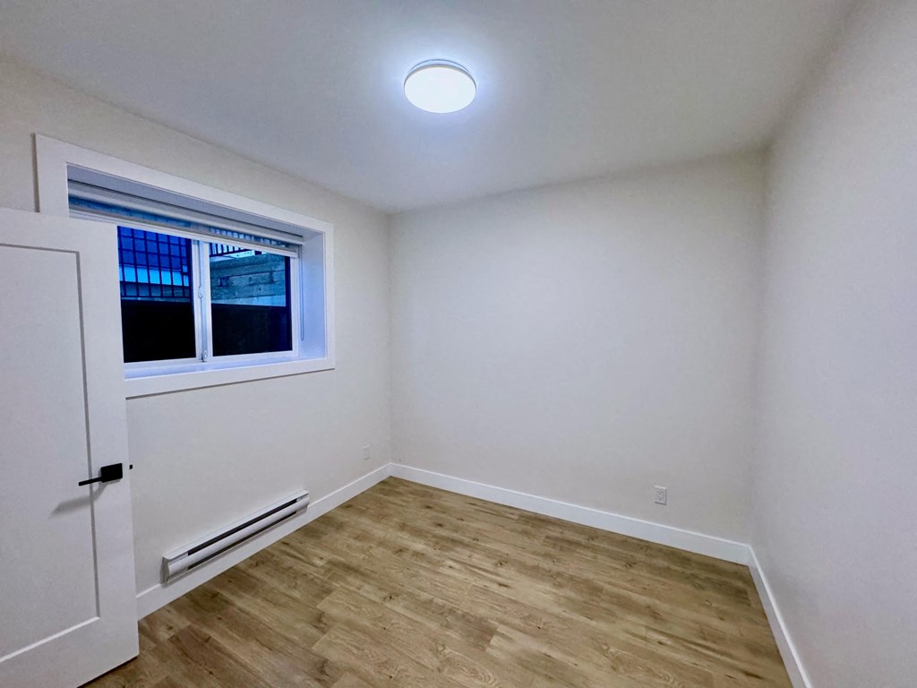 an empty room with white walls and a window