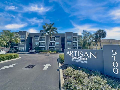 The Artisan building is a modern apartment complex with a clear blue sky in the background.