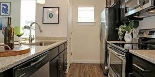 A kitchen with black cabinets and stainless steel appliances.