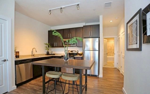 a kitchen with a wooden table with three stools
