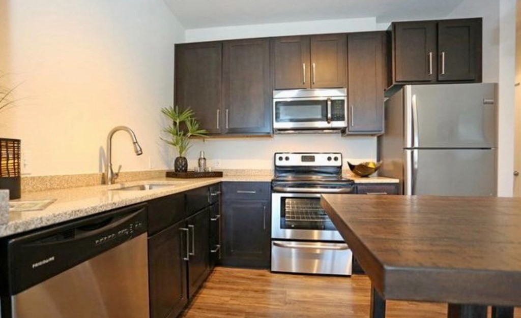 a kitchen with stainless steel appliances and a wooden table
