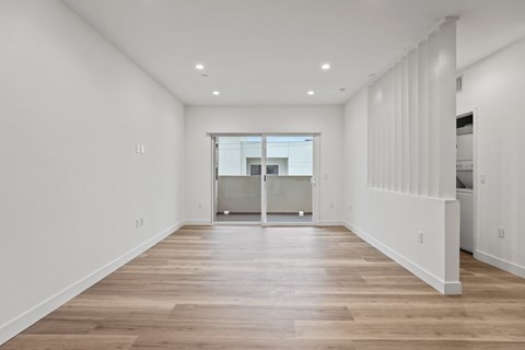 A spacious room with wooden floors and white walls.