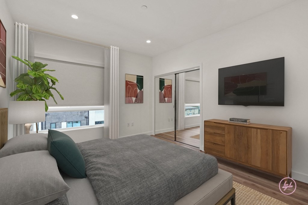 a bedroom with a bed and a tv and a door to a bathroom