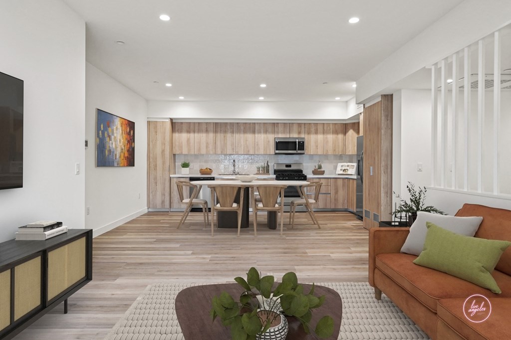 a living room with a couch and a table with a kitchen in the background