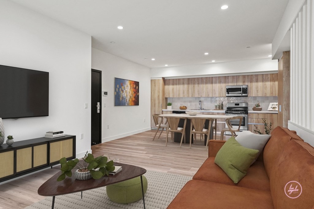 a living room with a couch and a table with a kitchen in the background