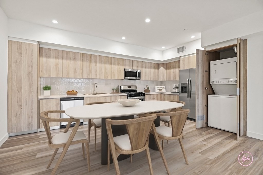 a kitchen with a white table and chairs and a white refrigerator and stove