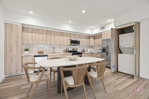 a kitchen with a white table and chairs and a white refrigerator and stove