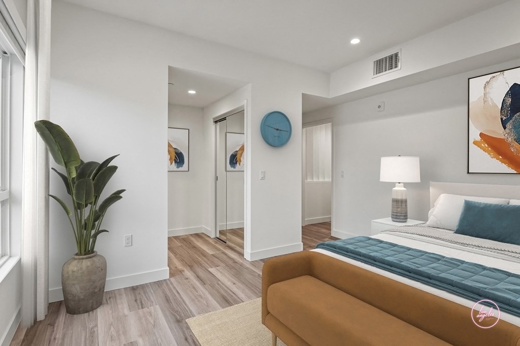 a bedroom with white walls and a bed and a couch