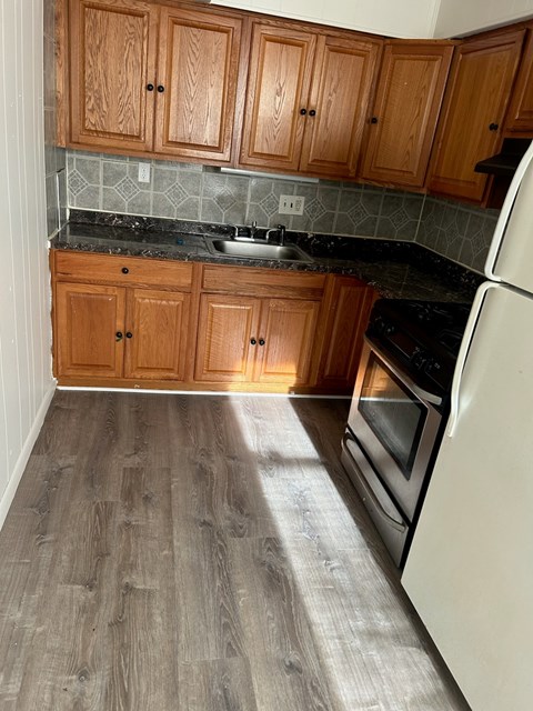 A kitchen with wooden cabinets and a white refrigerator.