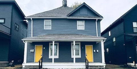 a blue house with two yellow doors