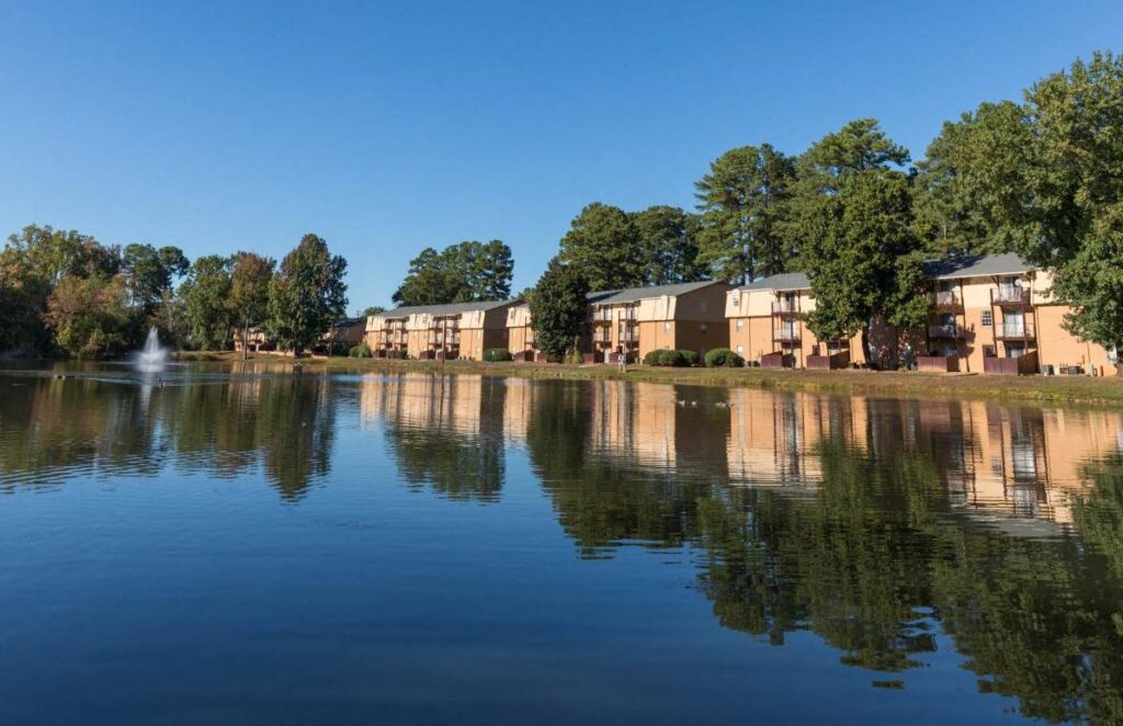 rows of apartments overlooking a lake with a fountain